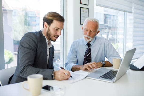 Young businessman cooperating with experienced colleague